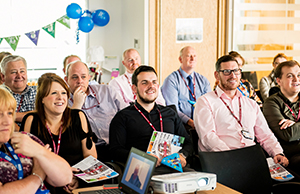 Photograph of NHS Informatics Merseyside colleagues listen to ten-year anniversary presentation